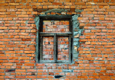 Old brick wall with wooden window